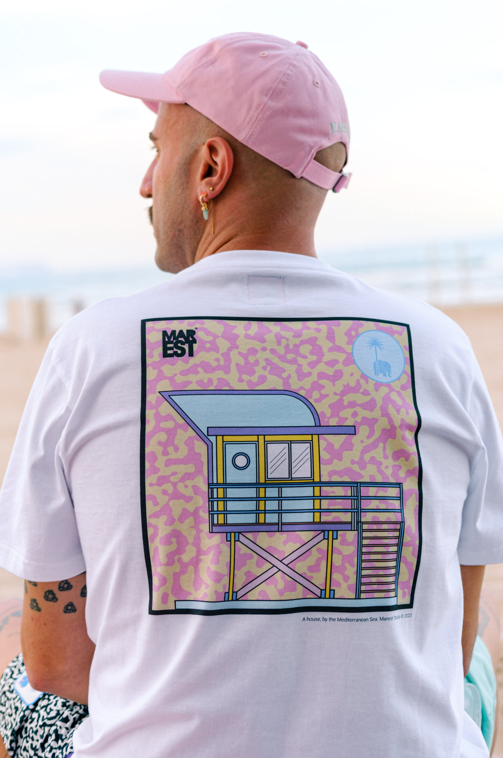 Persona che indossa una t-shirt bianca Antonyo Marest x Trendsplant Art Hut, vista posteriore | TP_IMAGE_TYPE=MODEL_BACK