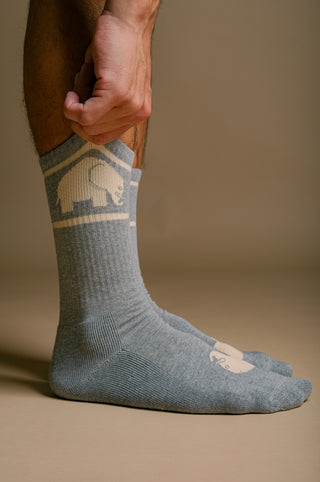 Person wearing grey organic cotton athletic socks, adjusting the sock | TP_IMAGE_TYPE=MODEL_FRONT
