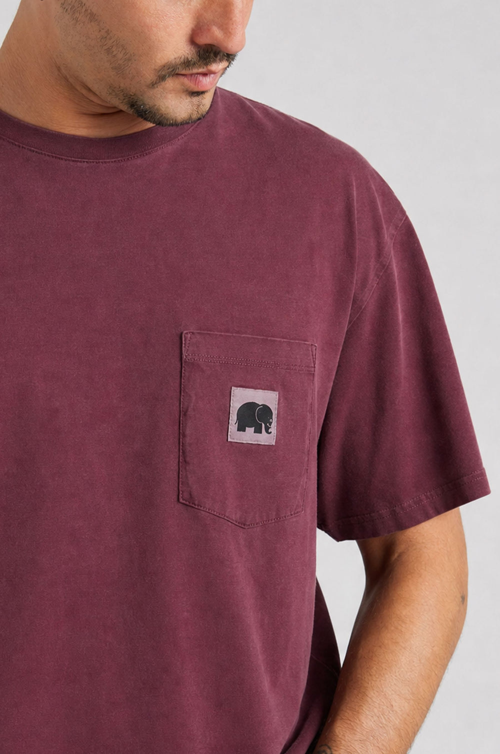 Persona che indossa una camicia Garza Cabernet con un dettaglio sulla tasca caratterizzato da una grafica con elefante | TP_IMAGE_TYPE=MODEL_FRONT