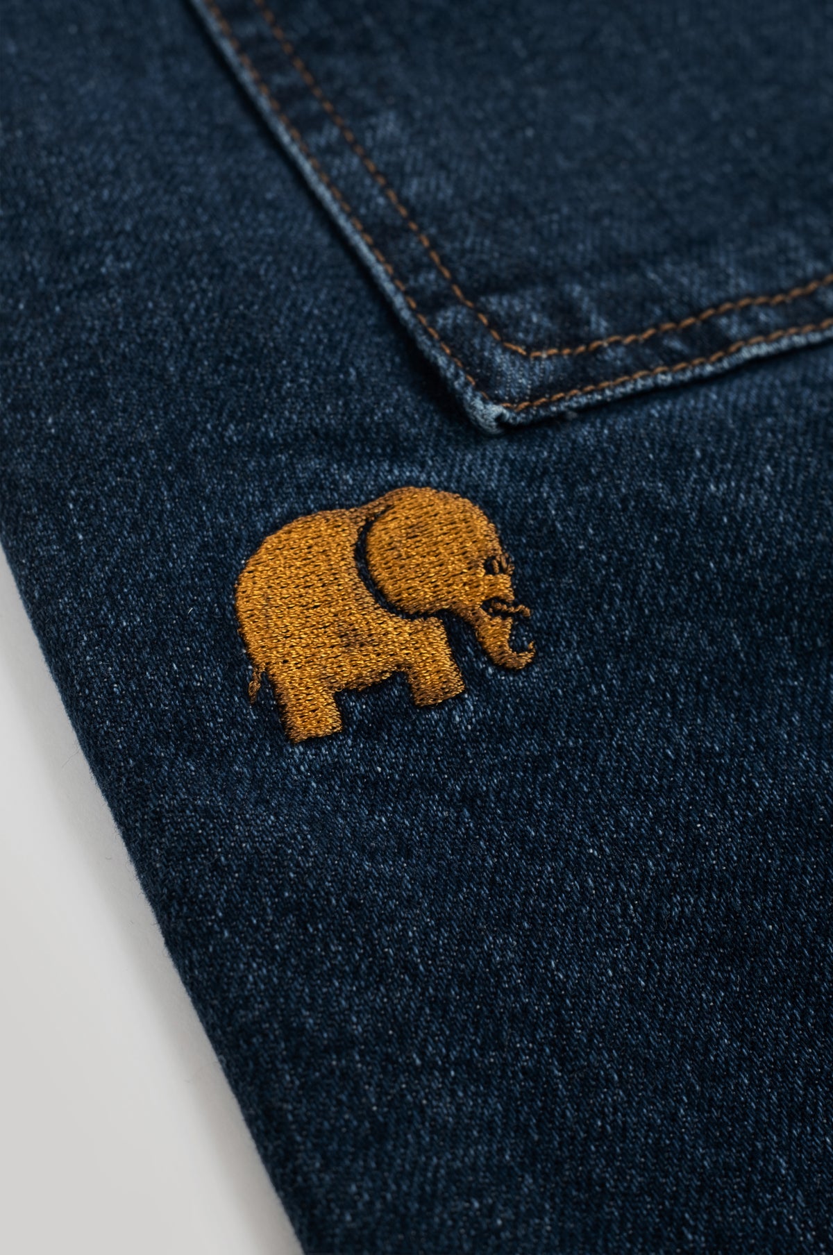 Gros plan sur l'éléphant brodé du short d'escalade en denim recyclé, lavage foncé | TP_IMAGE_TYPE=DETAIL