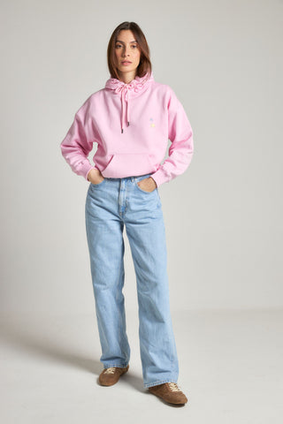 Personne portant la Women's Antonyo Marest x Trendsplant Oversized Hoodie en Gum Pink, associée à un jean bleu clair et à des chaussures décontractées | TP_IMAGE_TYPE=MODEL_FRONT