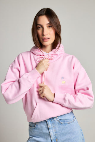 Personne portant un sweat à capuche oversize pour femme rose bubble-gum, orné d'un motif graphique ludique, associé à un jean bleu clair. | TP_IMAGE_TYPE=MODEL_FRONT