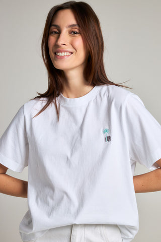 Person wearing a white t-shirt featuring a palm tree and elephant design, front view | TP_IMAGE_TYPE=MODEL_FRONT