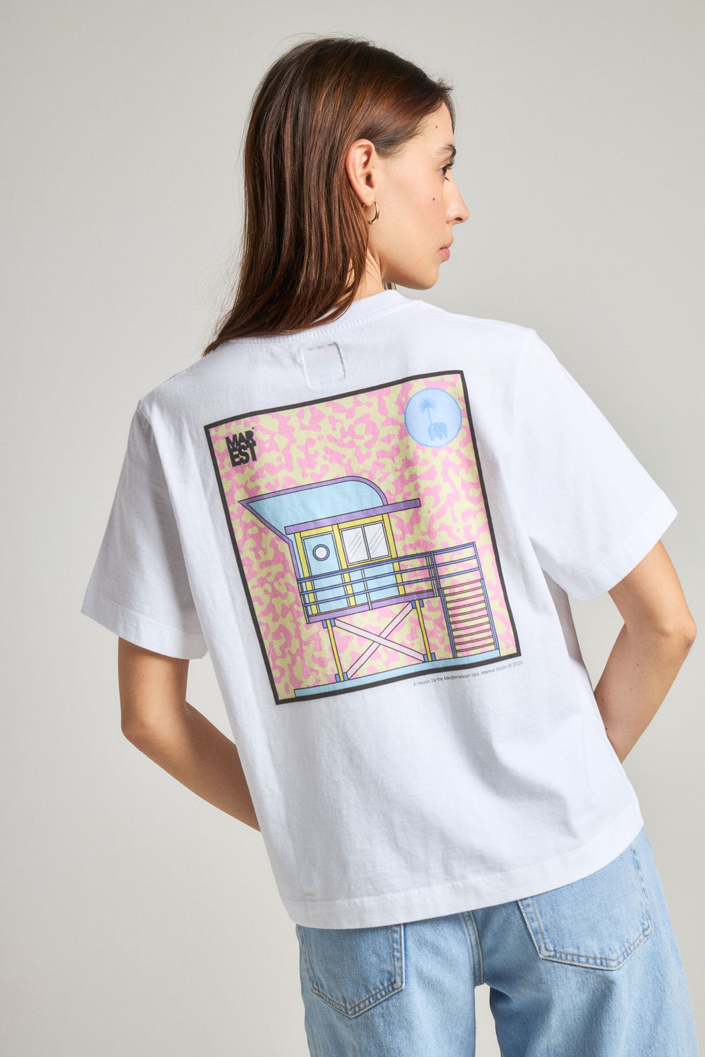 Persona che indossa una t-shirt bianca con grafica colorata, vista posteriore | TP_IMAGE_TYPE=MODEL_BACK