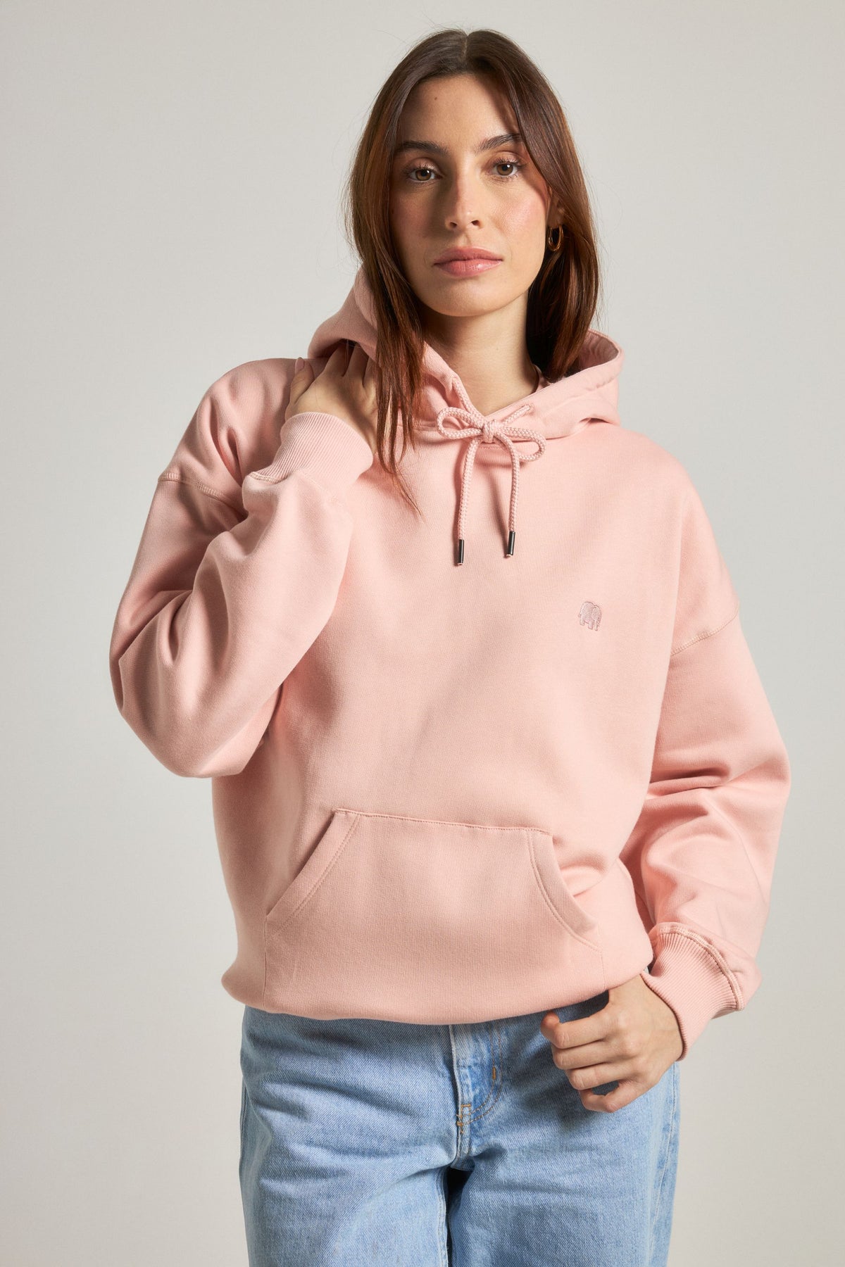 Personne portant un Women's Organic Essential Oversized Hoodie en Pale Pink, vue de face | TP_IMAGE_TYPE=MODEL_FRONT