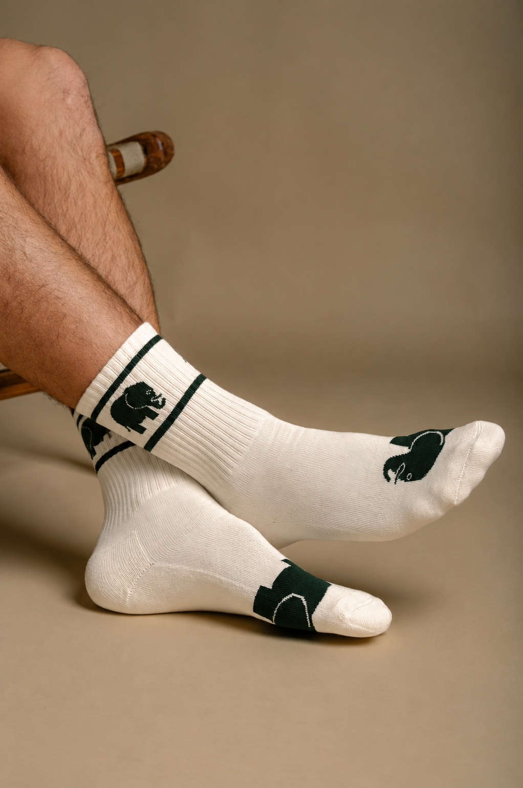 Persona che indossa calzini Athletic Cotton Crew Socks color avorio con disegni verdi, seduta su una sedia | TP_IMAGE_TYPE=MODEL_FRONT