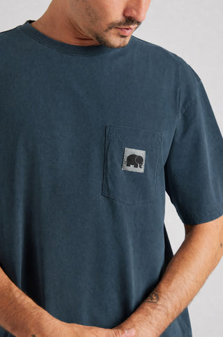 Persona che indossa una camicia a maniche corte blu navy con tasca sul petto decorata con un disegno di elefante, dal fit rilassato e dallo stile casual. | TP_IMAGE_TYPE=MODEL_FRONT