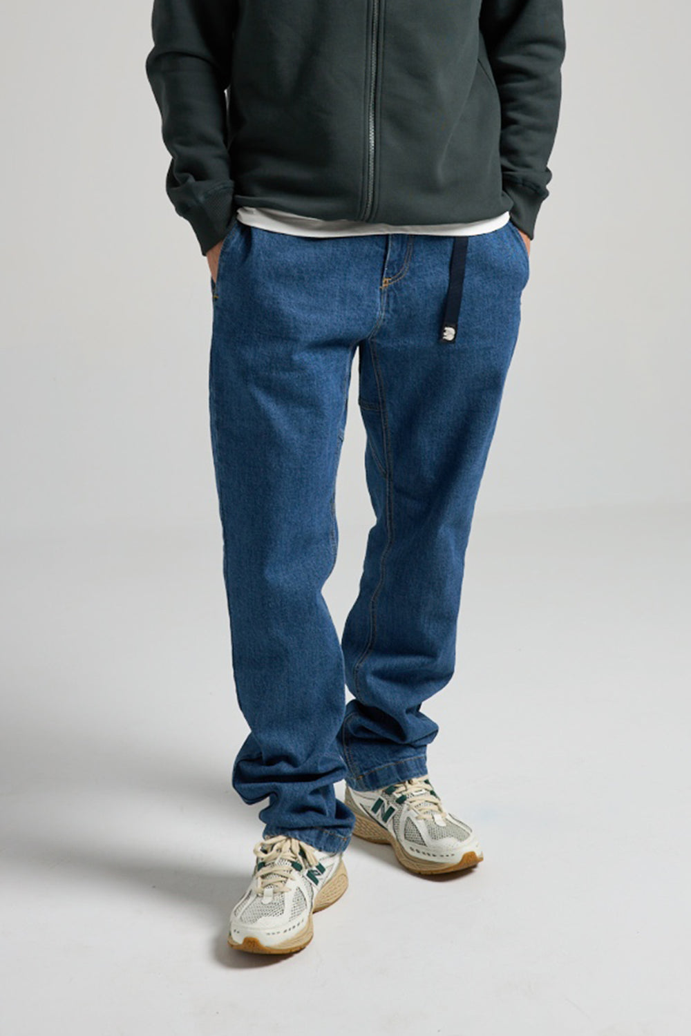 Persona che indossa Climber Pant in denim riciclato, lavaggio medium, abbinati a una felpa scura e sneakers | TP_IMAGE_TYPE=MODEL_FRONT