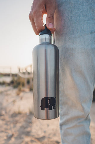 Persona che tiene in mano una Laken x Trendsplant Classic Thermo Bottle con un logo elefante all'aperto | TP_IMAGE_TYPE=LIFESTYLE